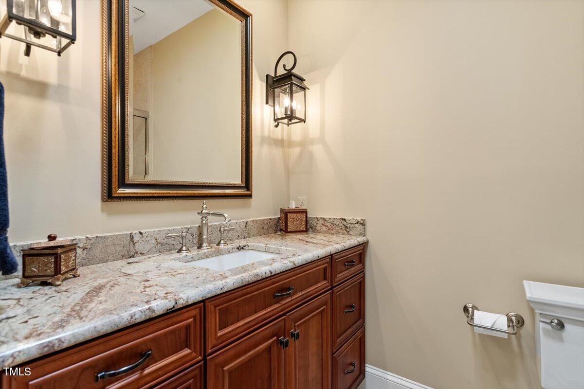 919 Woodham Pittsboro, NC 27312 - Photo 32 of 43 a bathroom with a granite countertop sink and a mirror