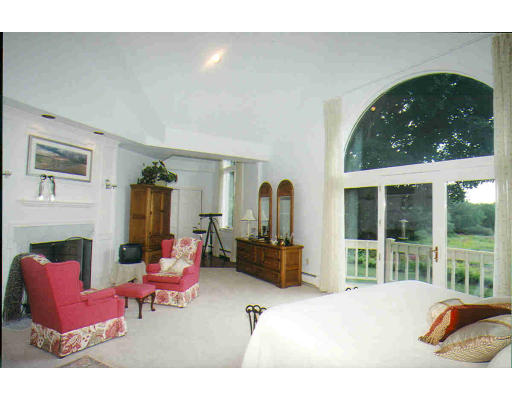 336 Lexington Road Concord, MA 01742 - Photo 7 of 10 a living room with furniture a fireplace and a floor to ceiling window