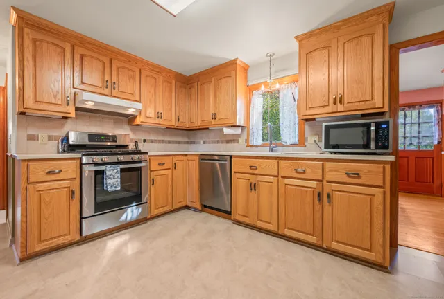 a kitchen with stainless steel appliances granite countertop a stove sink and cabinets