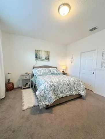 a bedroom with a bed and a lamp on desk