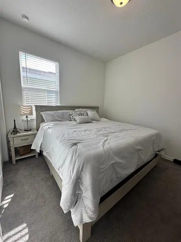a bed sitting in a bedroom next to a window