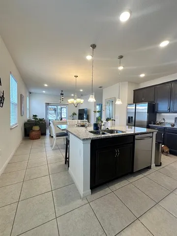 a large kitchen with kitchen island a sink a counter top and stainless steel appliances