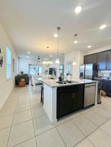 a large kitchen with kitchen island a sink a counter top and stainless steel appliances