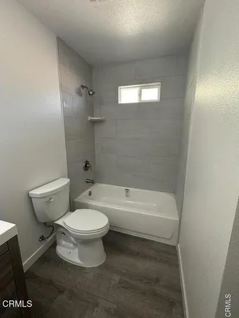 a white toilet sitting next to a bath tub
