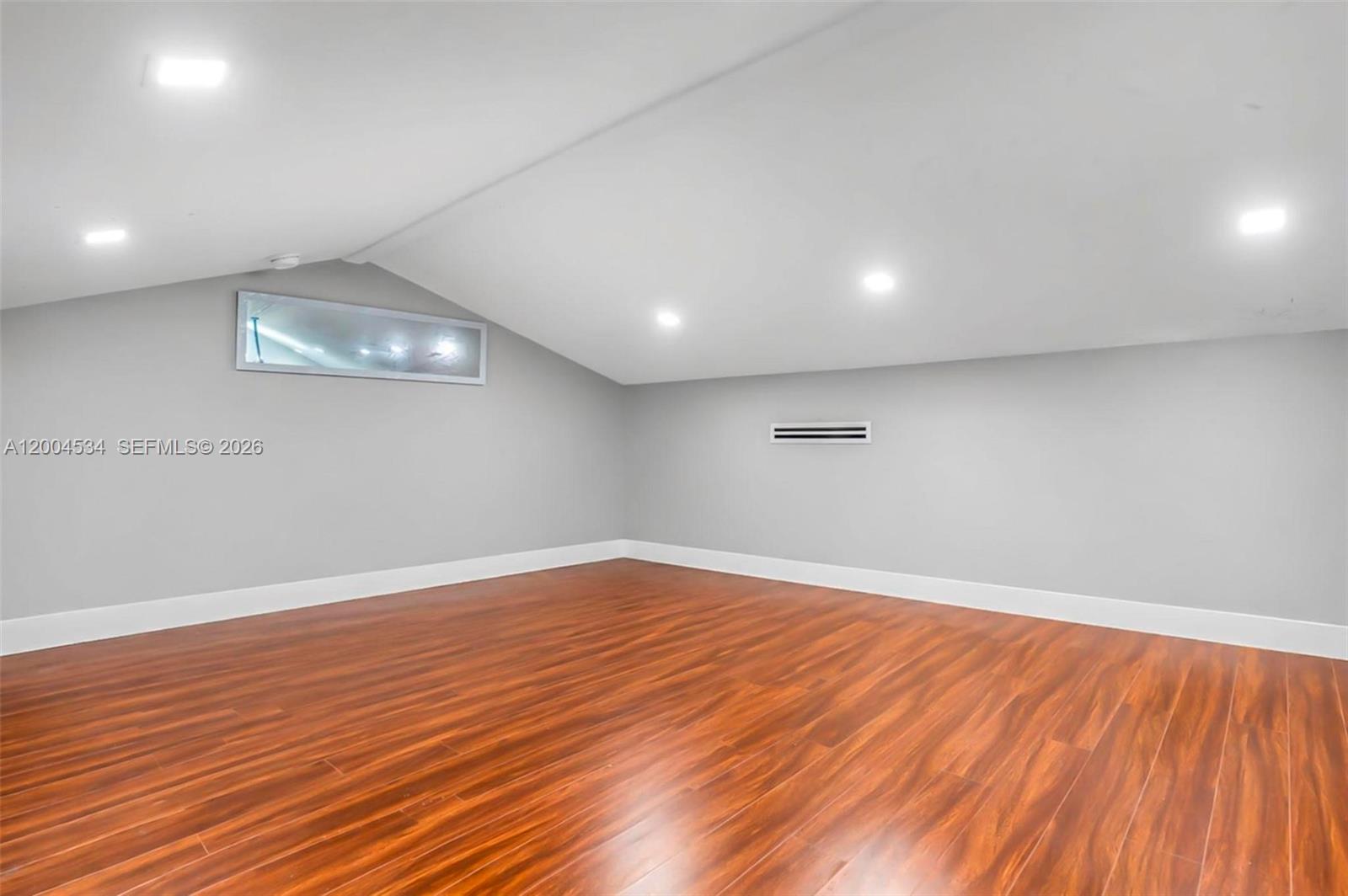 1741 Northwest 44th Street Miami, FL 33142 - Photo 18 of 45 an empty room with wooden floor and windows