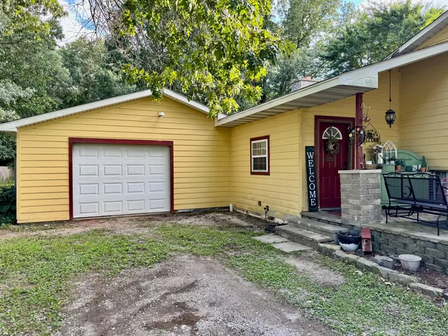 a front view of house with yard and trees in the background