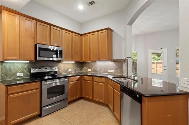 a kitchen with stainless steel appliances granite countertop a sink stove and microwave