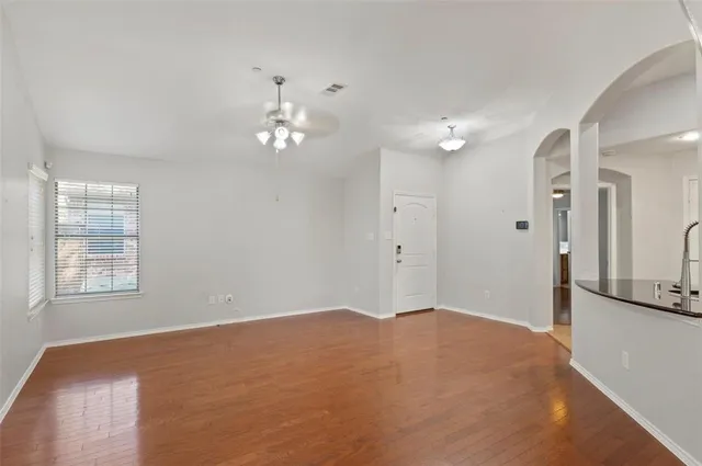 a view of a livingroom with a chandelier fan and windows