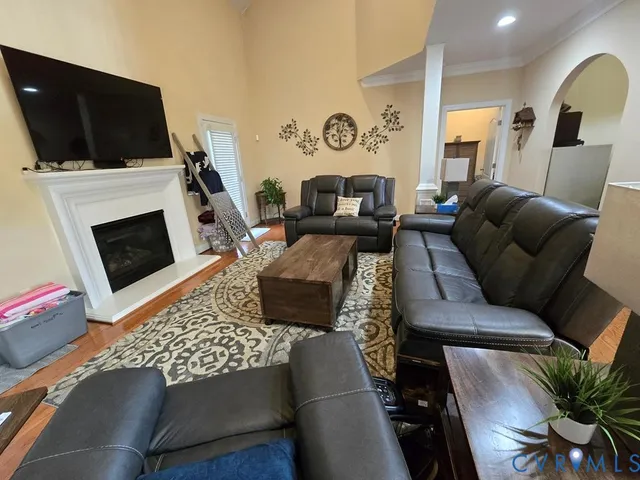 a living room with furniture a flat screen tv and a fireplace