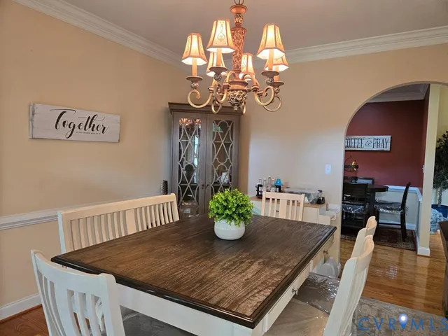 a view of a dining room with furniture wooden floor and chandelier