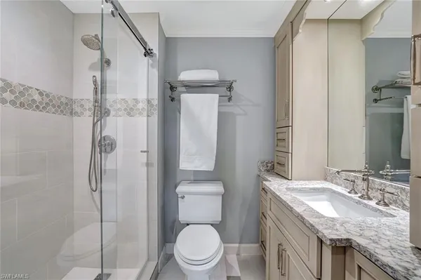 a bathroom with a granite countertop sink toilet and shower