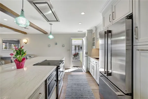 a kitchen with stainless steel appliances kitchen island granite countertop a refrigerator a stove and a sink