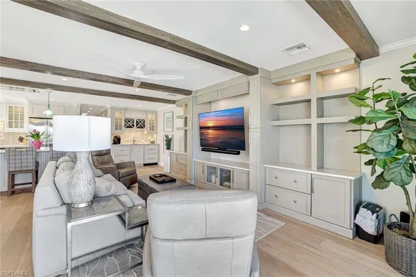 a living room with furniture a flat screen tv and a potted plant