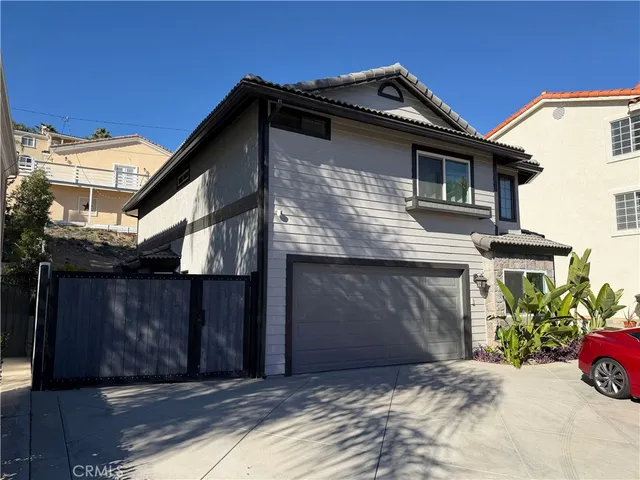 a view of a house with a small yard and potted plants