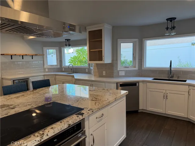 a kitchen with granite countertop a sink and stove top oven