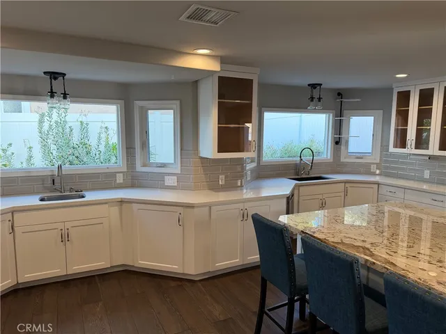 a kitchen with stainless steel appliances granite countertop a sink table and chairs