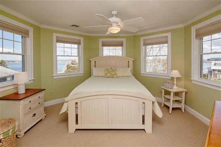 163 Jefferson Road Bourne, MA 02532 - Photo 23 of 35 a spacious bedroom with a bed next to a window and a chandelier