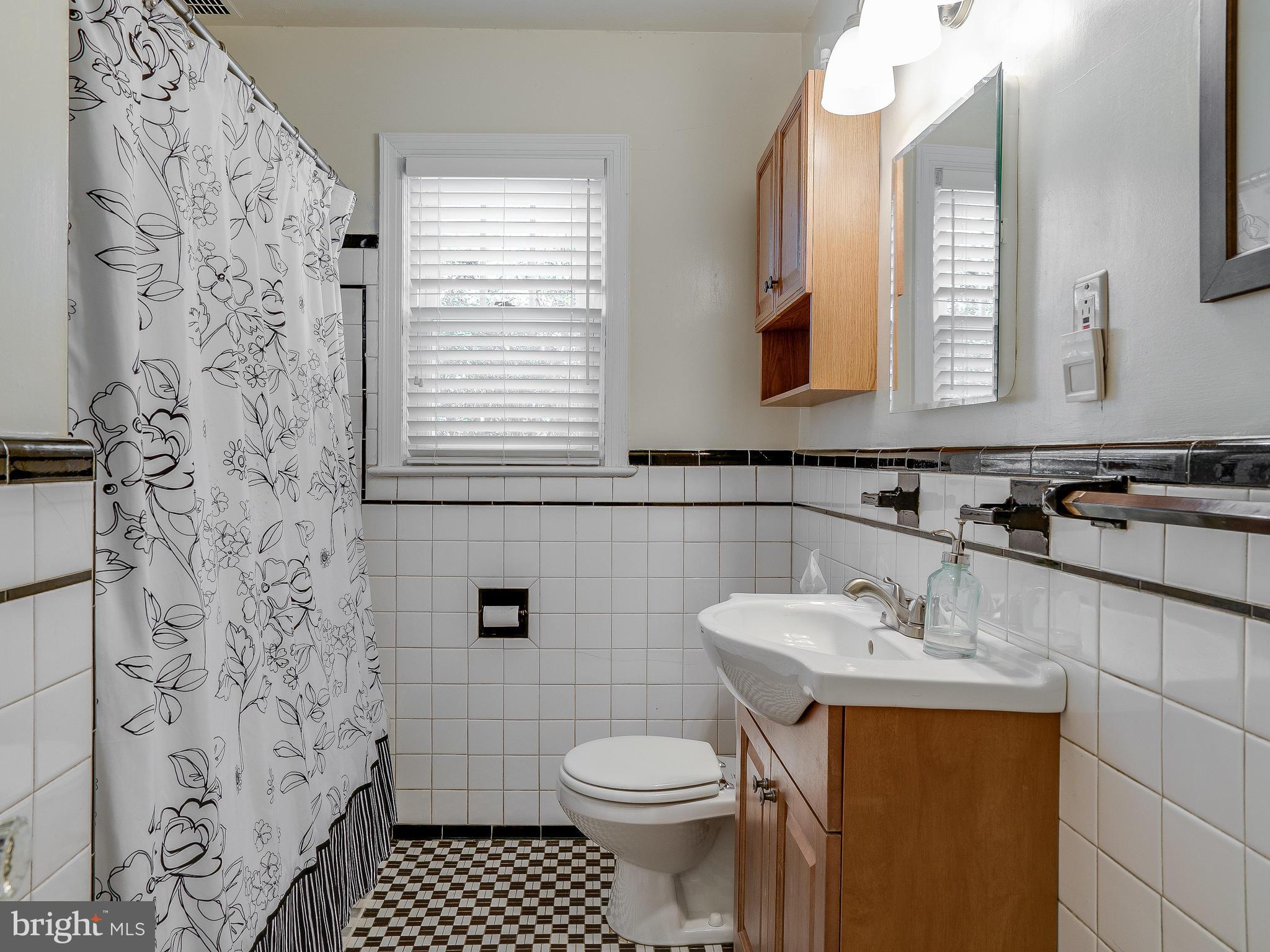 9504 Seminole Street Silver Spring, MD 20901 - Photo 12 of 25 a bathroom with a sink a toilet and a mirror