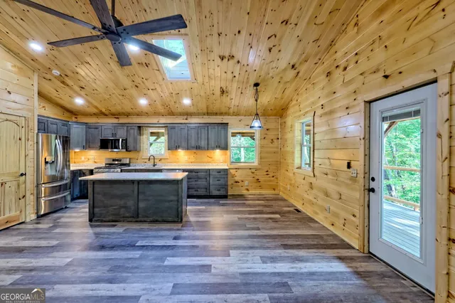 a view of wooden house with a small yard and wooden fence