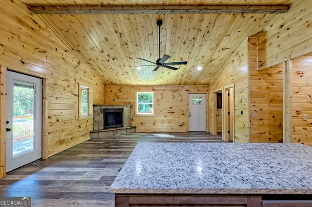 a view of a hallway with wooden floor and a bathroom