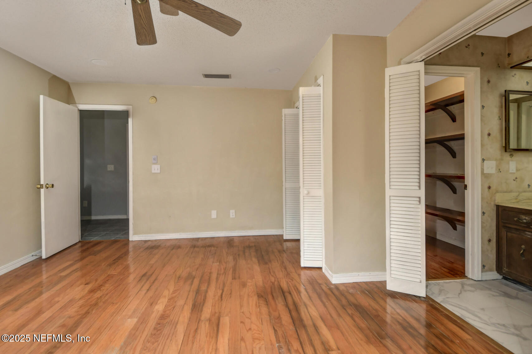12876 Squirrel Tree Court Jacksonville, FL 32246 - Photo 29 of 33 an empty room with wooden floor closet and windows