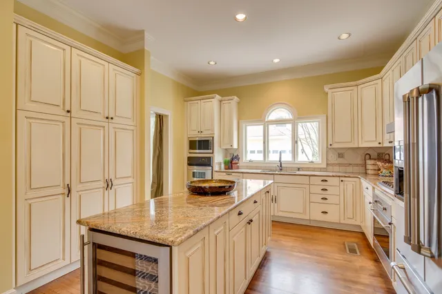 a kitchen with granite countertop white cabinets and white appliances