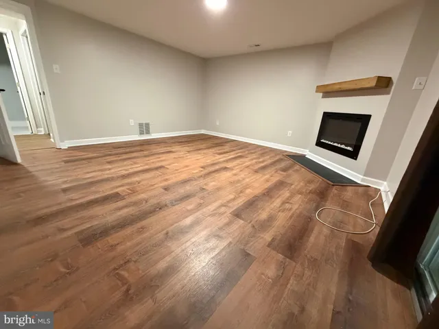 a view of a livingroom with wooden floor and a flat screen tv