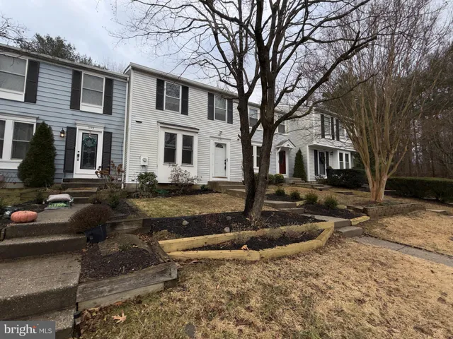 a front view of a house with a yard covered with snow