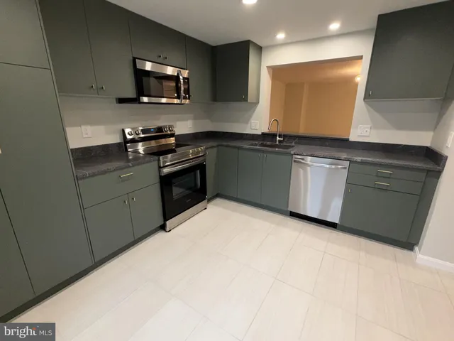 a kitchen with granite countertop a sink and a stove top oven