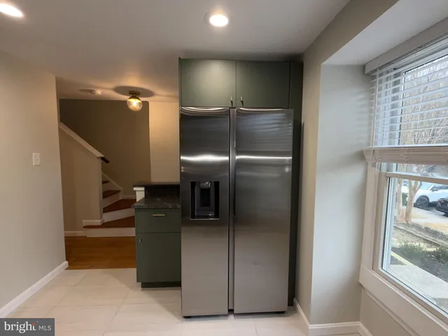 a kitchen with metallic refrigerator and window