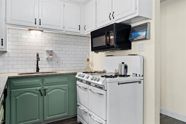 a kitchen with granite countertop cabinets stainless steel appliances and a sink