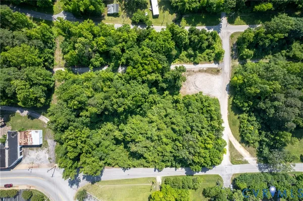 an aerial view of residential house with outdoor space and trees all around