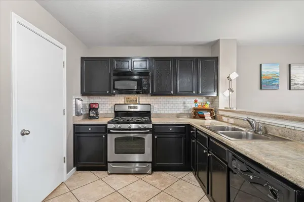 a kitchen with stainless steel appliances granite countertop a sink stove oven and refrigerator