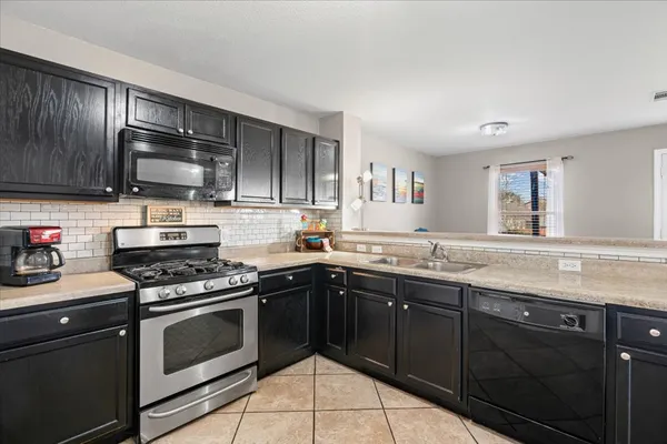 a kitchen with granite countertop wooden cabinets and stainless steel appliances