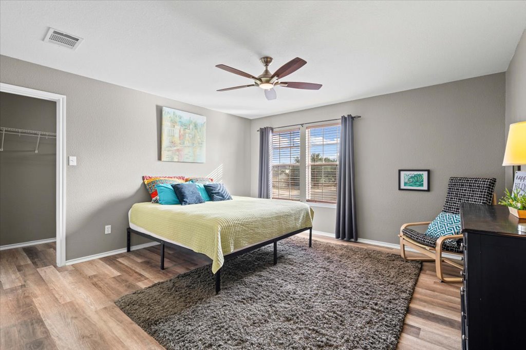 283 Black Forest Road Buda, TX 78610 - Photo 22 of 29 a bedroom with a bed and wooden floor