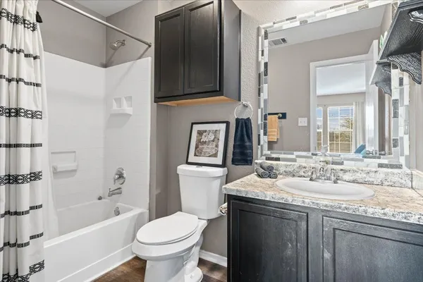 a bathroom with a granite countertop sink toilet and shower
