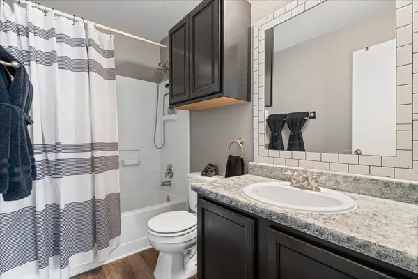 a bathroom with a granite countertop sink toilet and shower