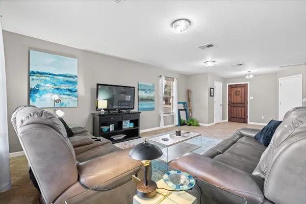 a living room with furniture large window and a flat screen tv