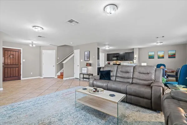 a living room with furniture and a wooden floor