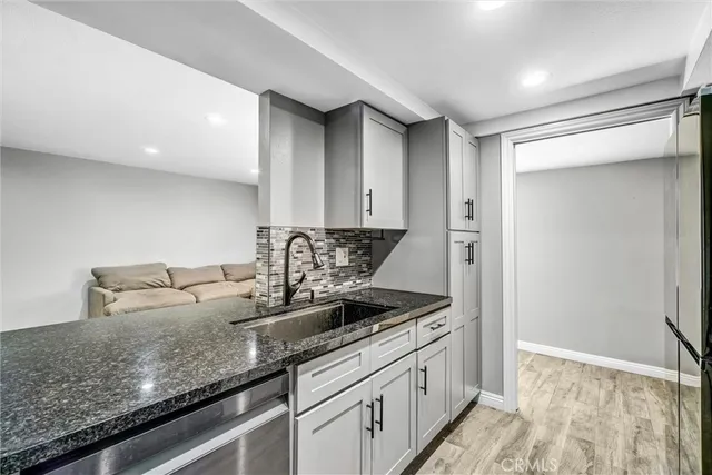 a kitchen with granite countertop a sink and a white cabinets