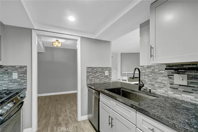 a kitchen with stainless steel appliances granite countertop a sink and a stove