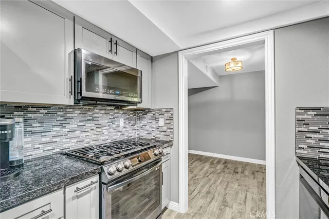 a kitchen with granite countertop a stove and a microwave