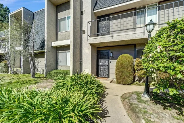a view of a house with large windows and plants
