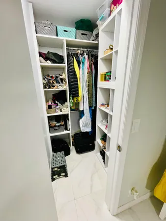 a view of walk in closet with clothes and shoes