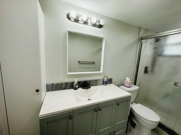 a bathroom with a sink and mirror with toilet