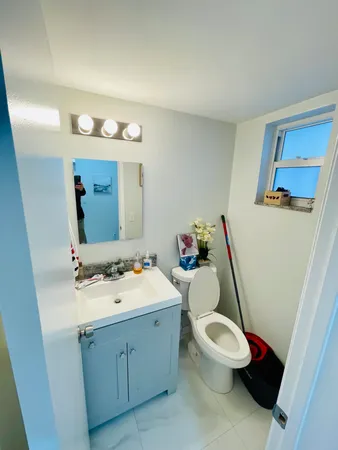 a bathroom with a sink vanity mirror and toilet