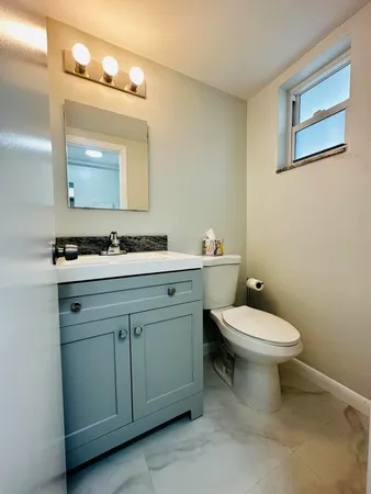 a bathroom with a toilet sink and mirror