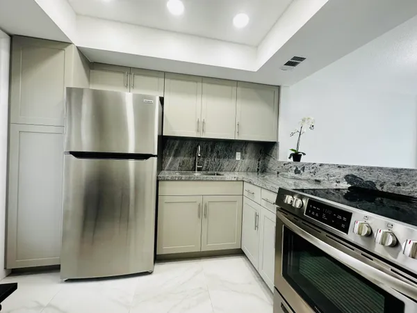 a kitchen with a refrigerator stove and sink
