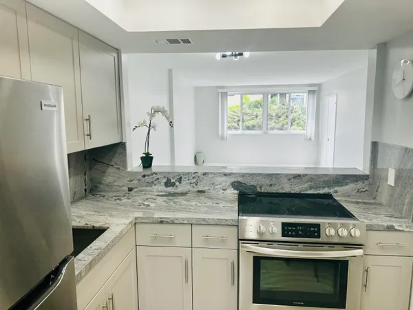 a kitchen with stainless steel appliances granite countertop a stove and a sink