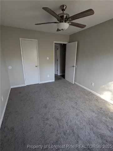 an empty room with a ceiling fan and a window